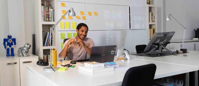 man op kantoor achter bureau en laptop