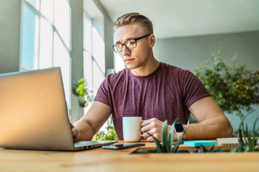 Zzp'er aan het werk achter laptop met kop koffie