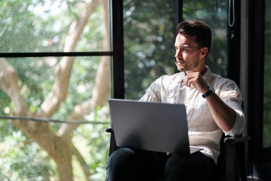 Mannelijke consultant met laptop op schoot