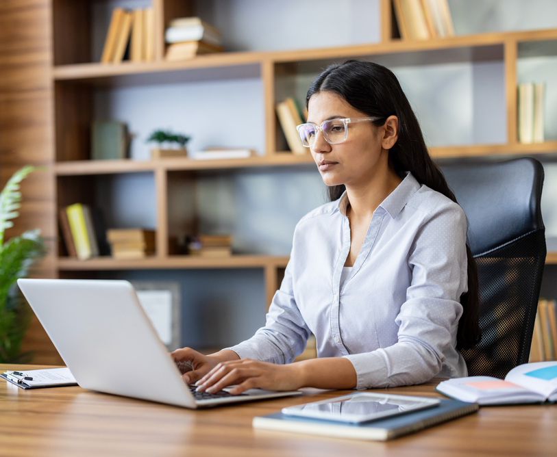 Jonge Indiase zakenvrouw achter haar laptop aan het werk