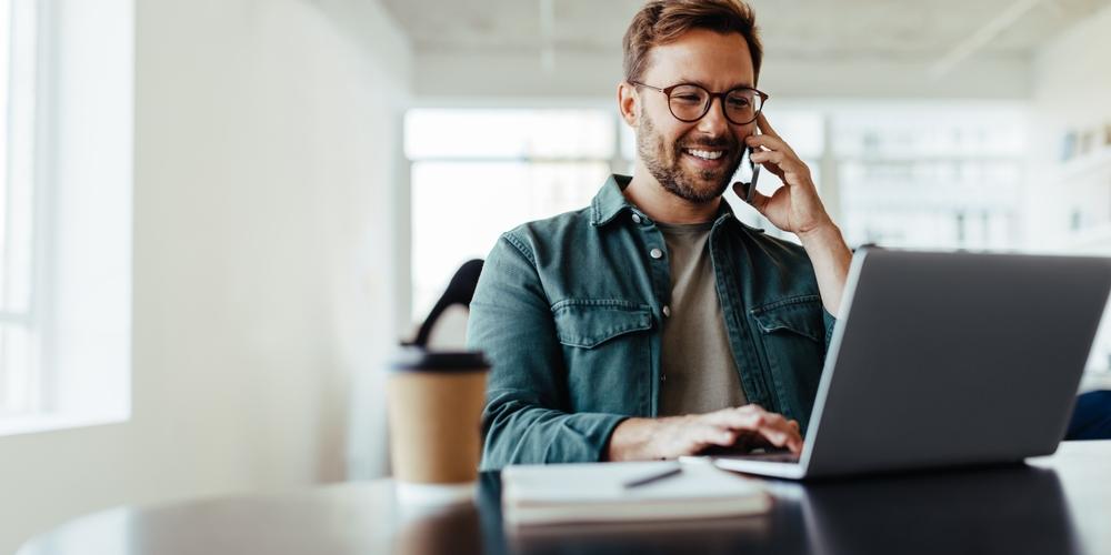 Zzp'er bellend aan het werk achter laptop