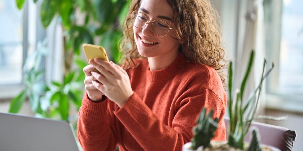 Jonge zzp'er kijkt op telefoon