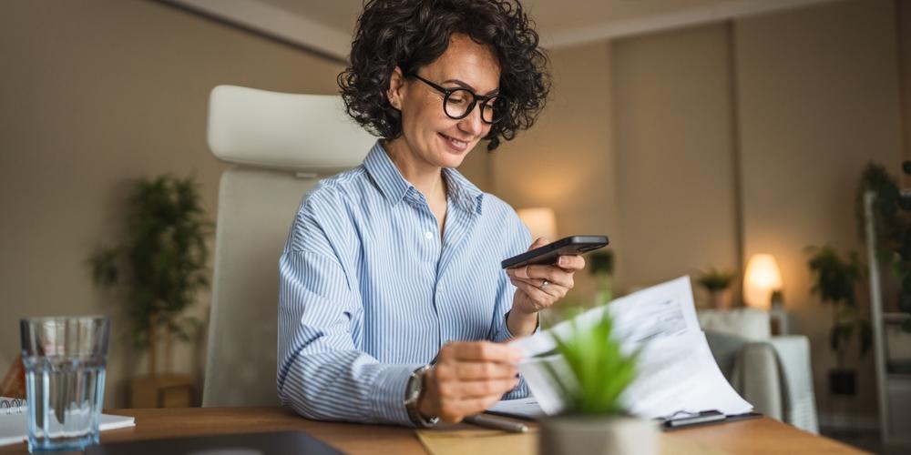 Vrouwelijke ondernemers rekent uren uit op telefoon