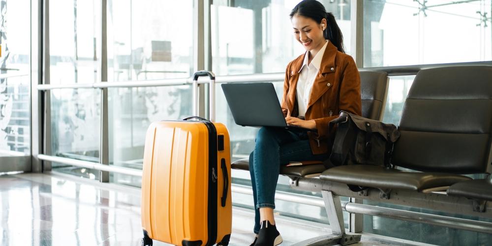 Reizende zakenvrouw zzp met laptop bij gate