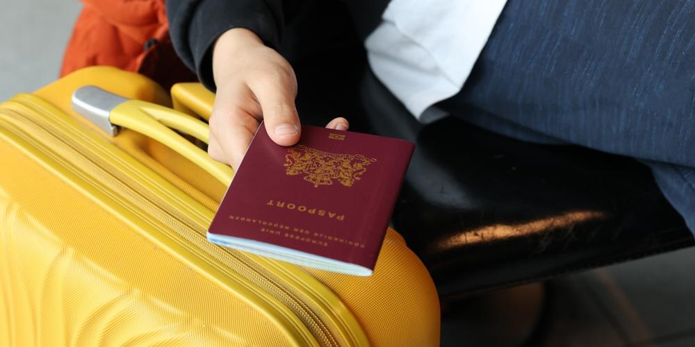 Zzp'er met koffer en paspoort in de hand